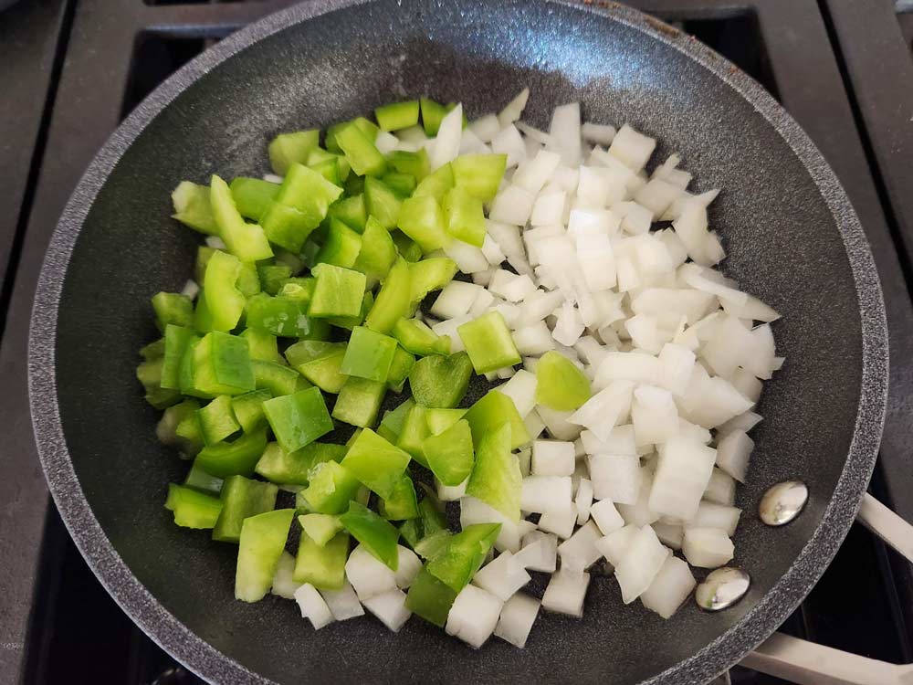 Raw onions and peppers in a pan