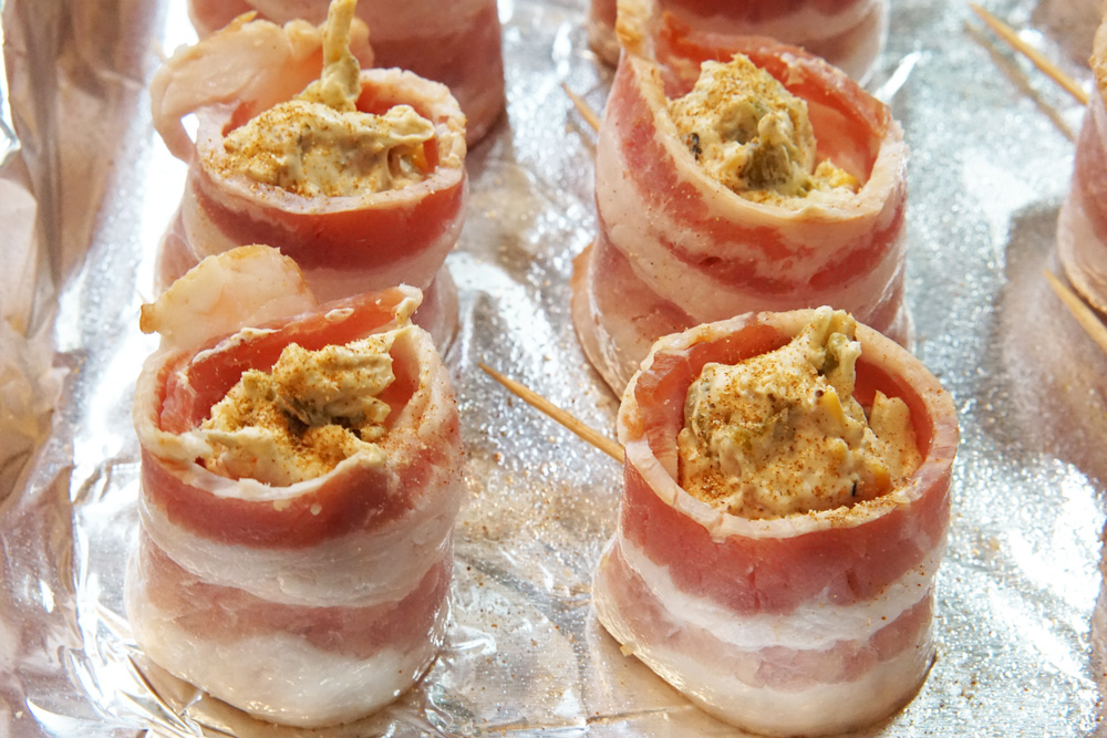 uncooked Bacon wrapped sausage with cream cheese filling