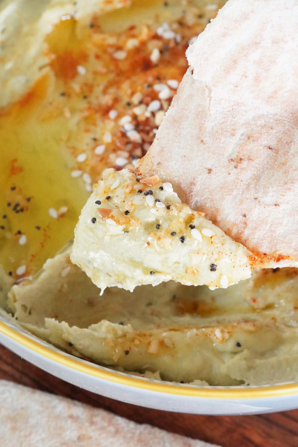 Everything bagel hummus scooped up on a cracker.