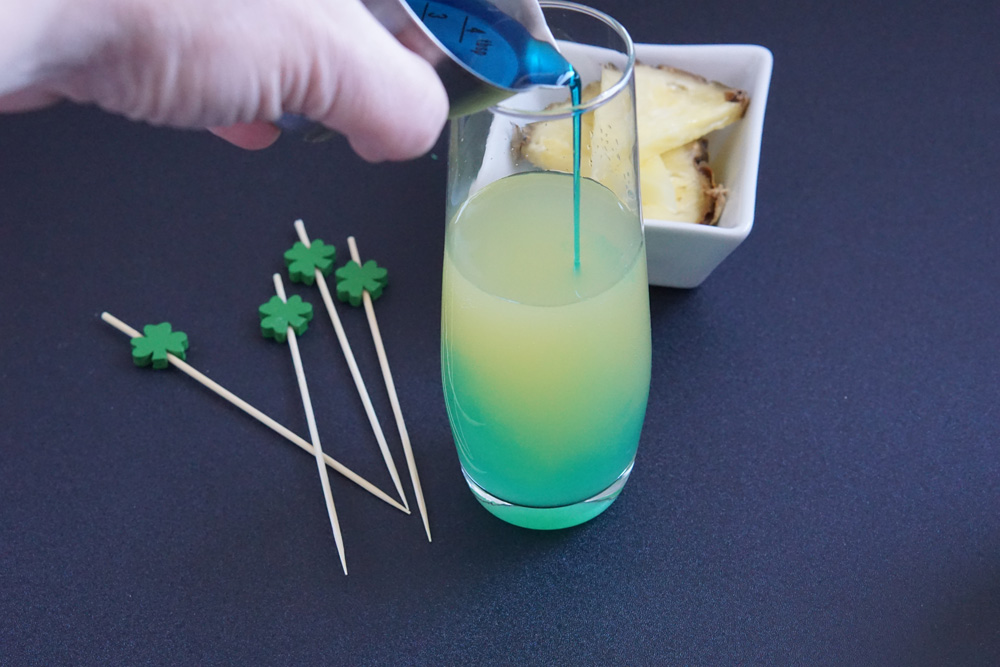 Pouring blue curacao into the cocktail